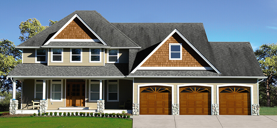house with three car garage with wooden garage doors